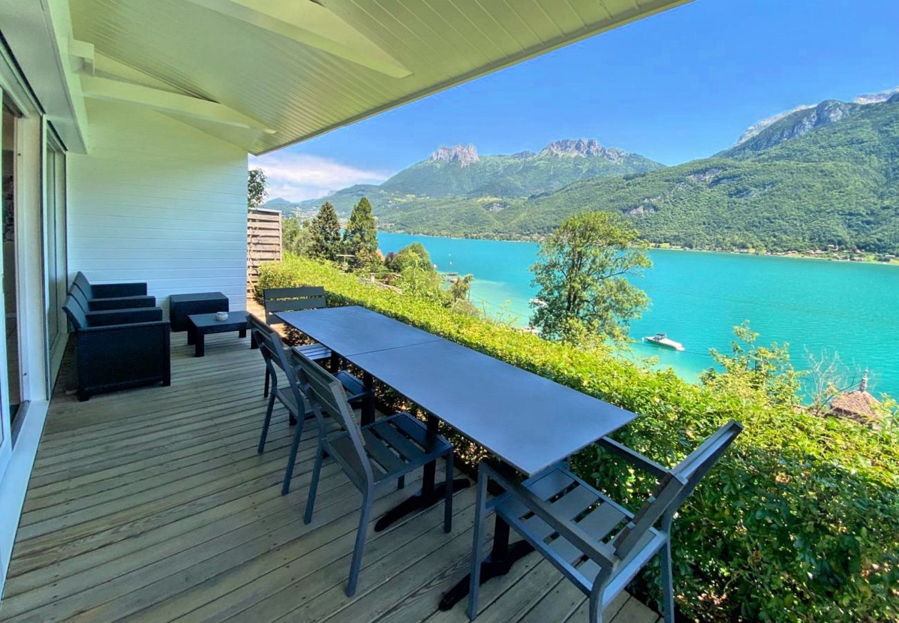 Beautiful terrace with a dining table and a view of the crystal-clear waters of Lake Annecy.